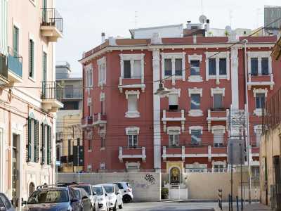 L�arteria termina davanti al muro che separa il quartiere dalla ferrovia, l� dove oltre i binari si staglia uno dei due splendidi palazzi presenti sulla breve via Tunisi. � quello rosso di quattro piani progettato tra il 1915 e il 1916 e caratterizzato da sfarzosi quanto inquietanti mascheroni